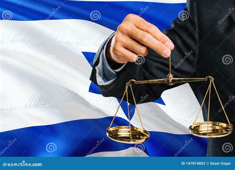 Israeli Judge Is Holding Golden Scales Of Justice With Israel Waving