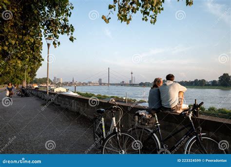 Couple Sit And Chill Out On Balustrade At Rheinuferpromenade Along