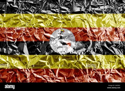 Uganda Flag Depicted In Paint Colors On Shiny Crumpled Aluminium Foil