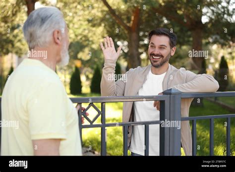 Friendly Relationship With Neighbours Happy Men Near Fence Outdoors