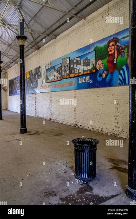 Large empty warehouse with some graffiti on one wall Stock Photo - Alamy