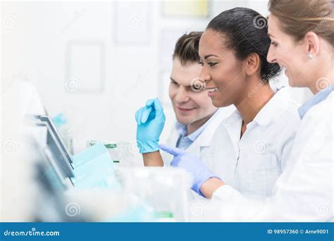 Group Of Researchers During Work On Devices In Laboratory Stock Photo