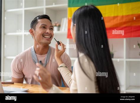 An Attractive Asian Gay Man Is Being Made Up By A Female Makeup Artist