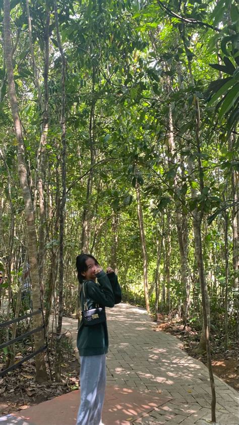 A Woman Standing On A Path In The Woods