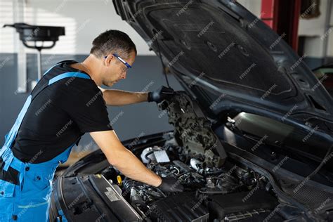 Mecánico De Automóviles Observando Las Piezas De Reparación Durante La