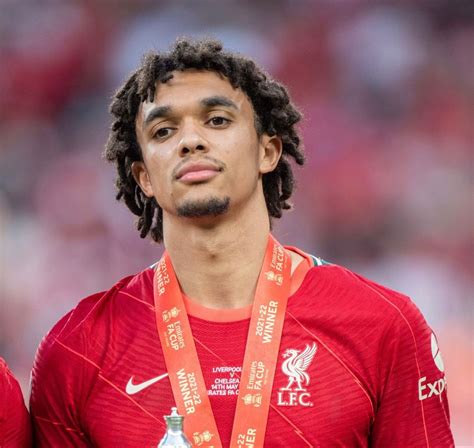 A Close Up Of A Person Wearing A Red Shirt And Holding A Silver Medal