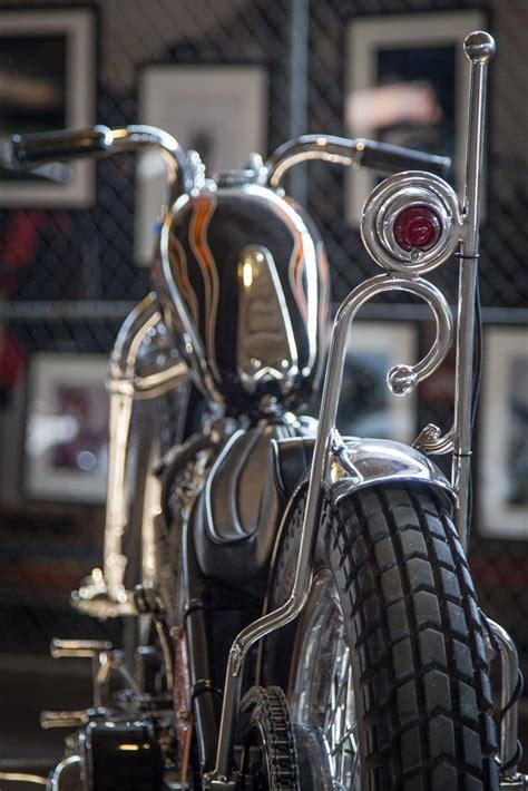 Two Motorcycles Parked Side By Side In Front Of A Chain Link Fence With