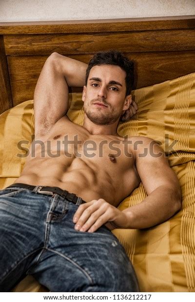 Shirtless Sexy Male Model Lying Alone On His Bed In His Bedroom