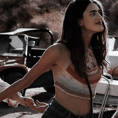 a woman standing next to a car in the desert