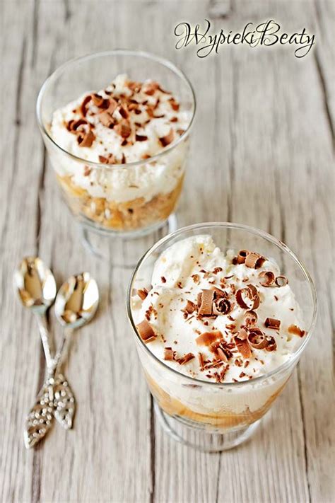 Two Desserts With Whipped Cream And Nuts In Small Glass Dishes On A