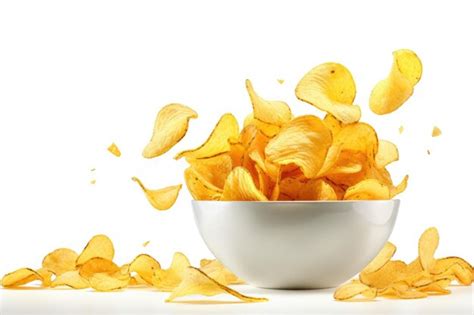 Premium AI Image Potato Chips Falling Into A Bowl Isolated On White