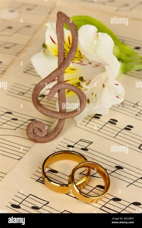 Treble Clef Flower And Wedding Rings On Musical Background Stock Photo