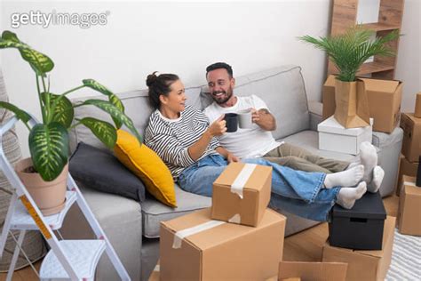 Young Couple Shares Cheers With Coffee Cups Unboxing And Moving Into