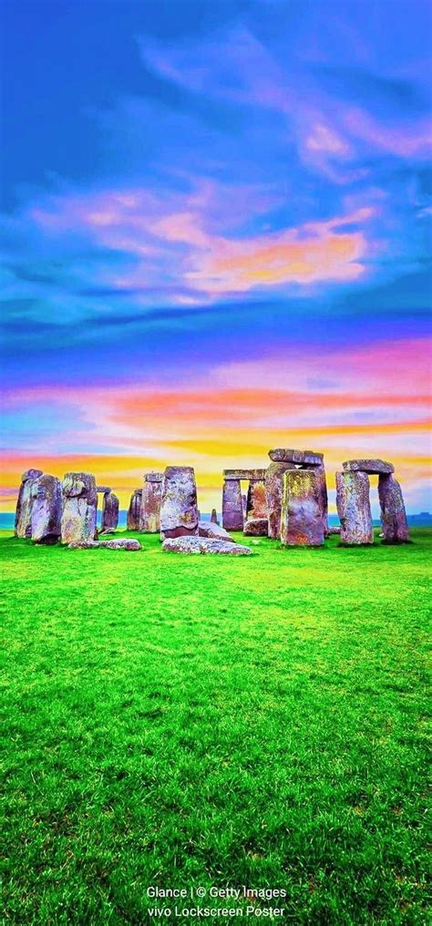 The Stonehenge Monument In England At Sunset With Green Grass And