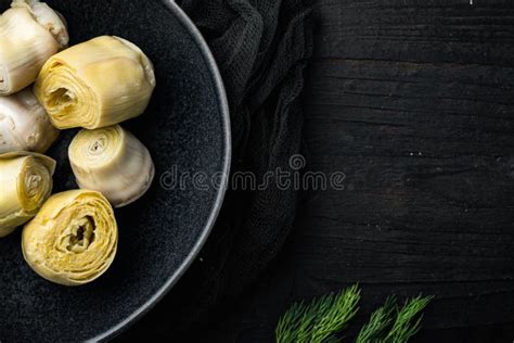 Pickled Artichokes In Oil On Black Wooden Table Top View With Space