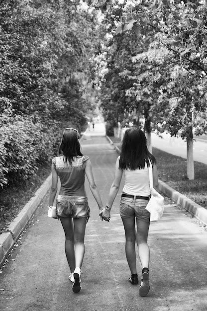 Premium Photo Rear View Of Sisters Holding Hands While Walking On