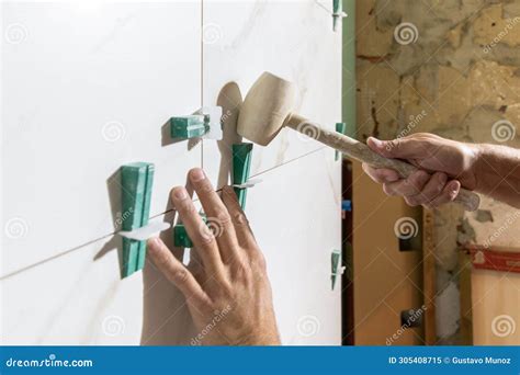 Close Up Detail Of Hands With Rubber Mallet Working In Installation