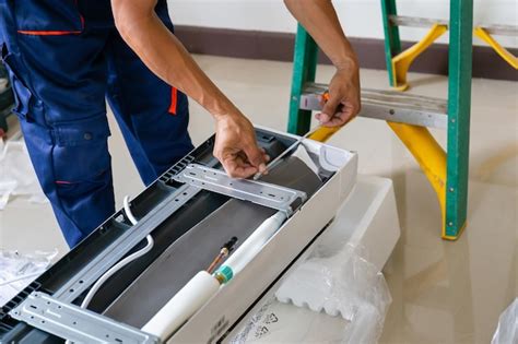 Hombre técnico instalando un aire acondicionado en la casa de un