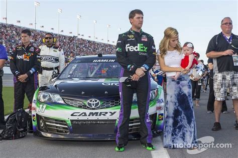 The Nascar Driver Is Standing Next To His Car With Two Women And Three