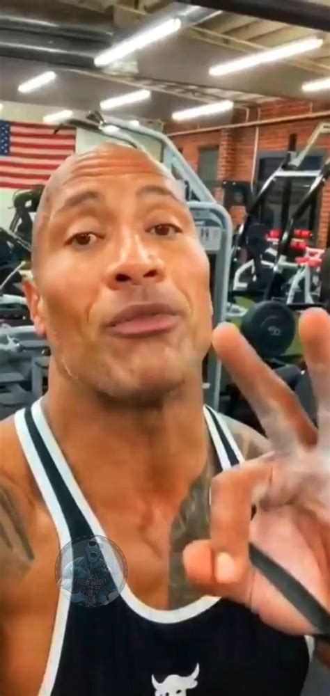 A Man Making The Peace Sign With His Hand In Front Of An Empty Gym Area