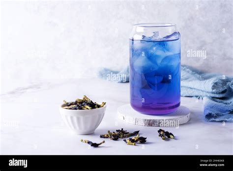 Iced Butterfly Pea Flower Tea And Dry Clitoria Ternatea Petals On White