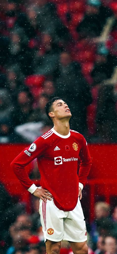 a man standing on top of a soccer field wearing a red shirt and white shorts