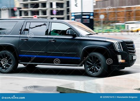 Side View Of Cadillac Escalade Suv In Motion Matte Black Big 4x4 Car Moving On The Street