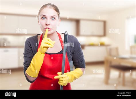 Female Cleaner Doing A Silence Gesture While Holding The Mop Inside The