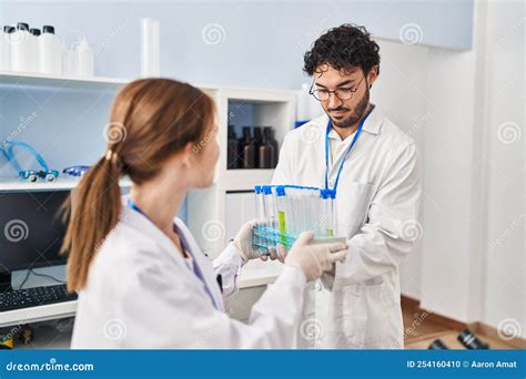 Man And Woman Scientist Partners Holding Test Tubes At Laboratory Stock