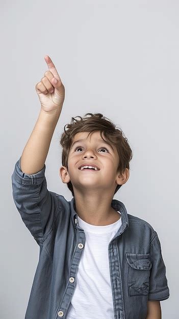 Un niño sonriente apuntando hacia arriba Imagen Premium generada con IA