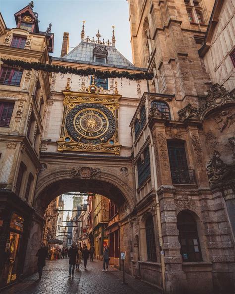 People Are Walking Under An Archway In The Middle Of A Street With A