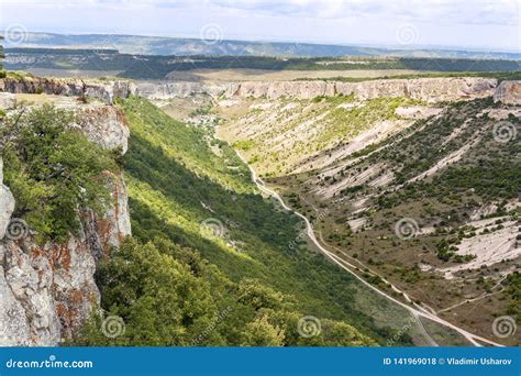 A Deep Canyon A Ravine Covered With Vegetation Grass Shrubs And