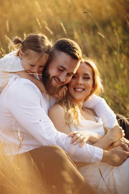 Premium Photo Mother With Father Hugging With Their Daughter In The Field