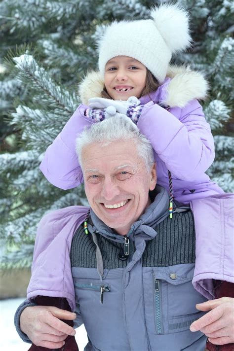 Portrait Of Grandfather With Granddaughter Smiling Posing Outdoors In