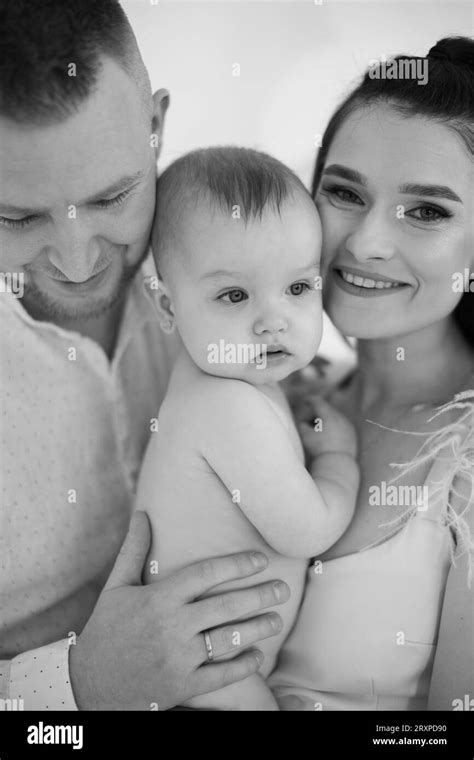 Mother Embracing Naked Baby While Father Gently Kissing Stock Photo Alamy