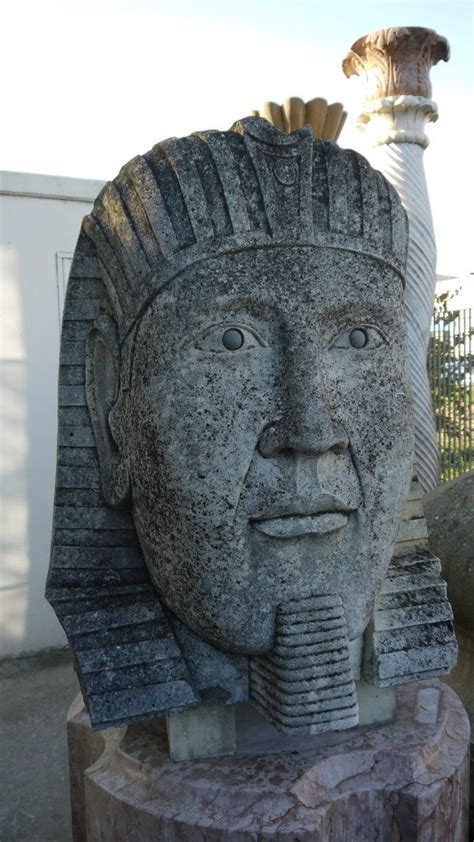 A Statue Of An Egyptian Head Is Shown In Front Of A Building