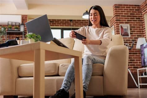 Mujer Asiática De Aspecto Auténtico Jugando Videojuegos Móviles En Línea En El Teléfono Ganando