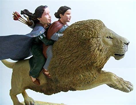 a figurine of two people riding on top of a lion's back