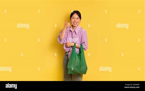 Positive Asian Woman Holding Reusable Eco Bag And Showing Thumb Up