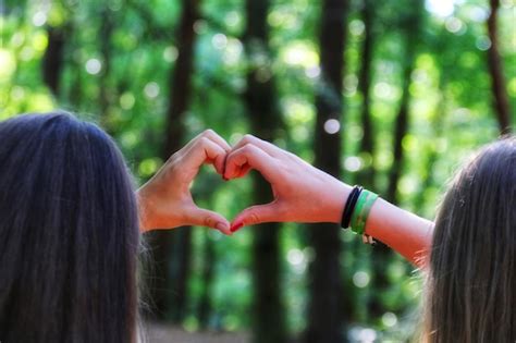 Premium Photo Female Friends Making Heart Shape With Hands At Forest