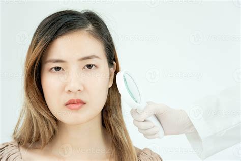 skin problem and beauty of asian girl. Dermatologist use magnifying