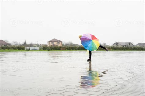 Beautiful Brunette Woman Holding Colorful Umbrella Dancing In The Rain