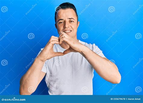 Handsome Young Man Wearing Casual White T Shirt Smiling In Love Doing Heart Symbol Shape With