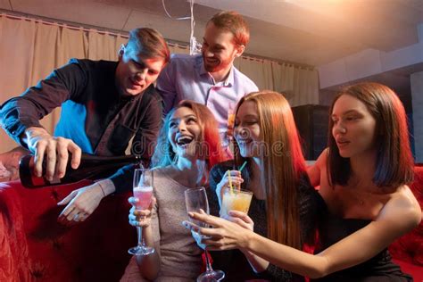 Group Of Young People Singing Into Microphone At Party Celebrating