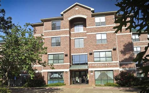 an apartment building with many windows and trees in front of the ...