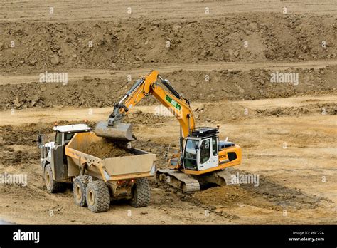 Jcb Digger Moving Soil Into Back Of Large Truck At Quarry Stock Photo