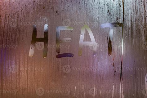 The Word Heat Written On Night Wet Window Glass Close Up With Bokeh