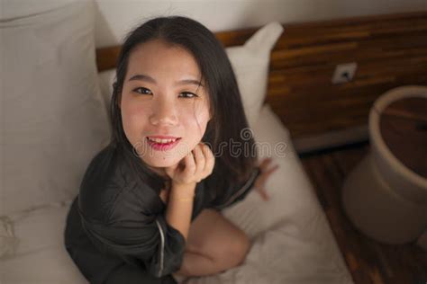 Young Beautiful And Sweet Asian Chinese Woman In Bed Feeling Happy And Relaxed Wearing Cute