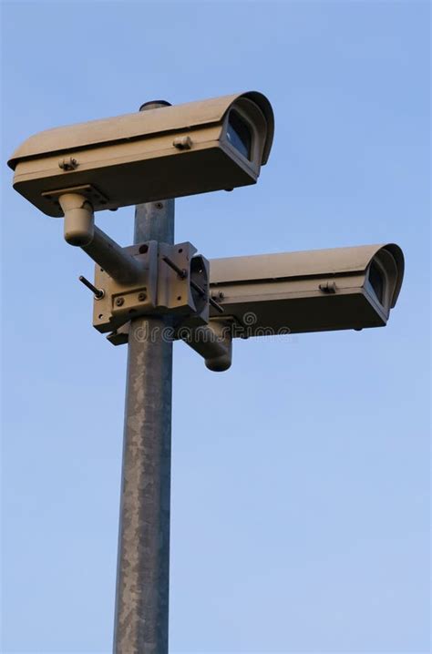 Surveillance Cameras Mounted On A Pole Against The Blue Sky Stock