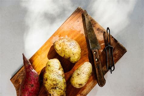 Vista Dell Angolo Alto Delle Patate Crude Sul Tagliere Di Legno Foto